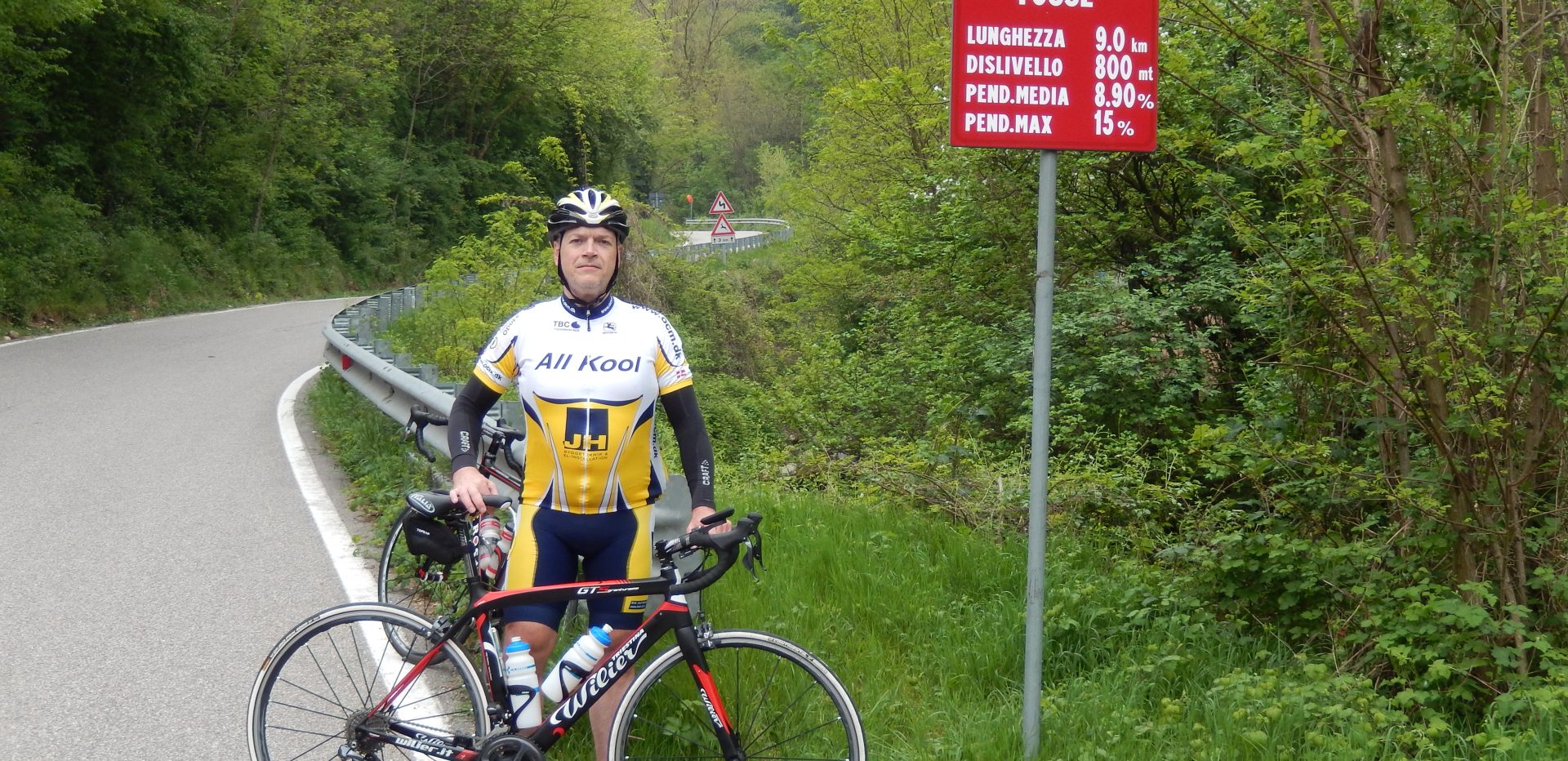 Michael Larsen står bag sin cykel på en landevej.